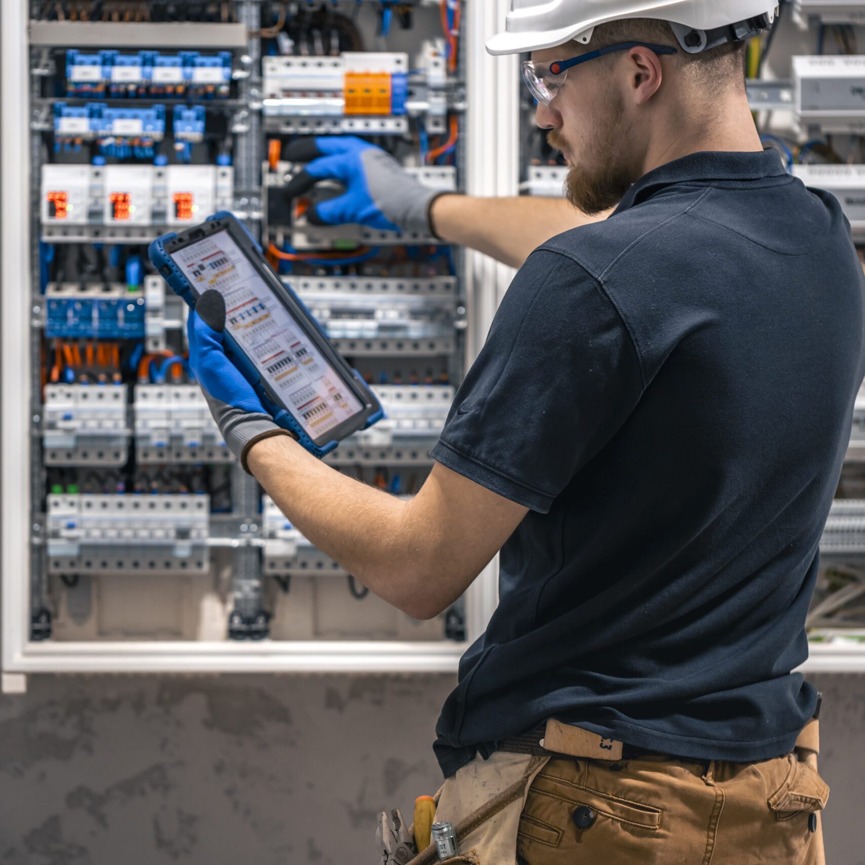 Electrical technician working in a switchboard with fuses, uses a tablet. Electrical technician looking focused while working in a switchboard with fuses. SSUCv3H4sIAAAAAAAACpySwW6DMAyG75P2DijnIgGBju5Vqh1MSMFqmlRJ6DRVffc5CaDsOnHBn+3f/jHP97eiYAM4FOyzeIaIYlRqcd6CR6MJV4eVW6lHaXPysPxY5QAwj+SI3lgElcMBvJg13CRBvSgV8CsmmfPgFydd2GVFArycSCPBXSItfE5xsSVikjooxdghY24ZIttQEv9XZ3r52g1PUoufuHBmxEolIRk5p1J2/fbS3nJrsIxoMlcPI0CFAp4pAd7Bwp++u0WBesqI8XO8y6YkzKK9DVvtZpgy5g6DCl/9QmPkxmdwjsrHjWezBf0F5pbN0cZHT6sqG+k4Iaw5747NBz193fZN1ZzWgnTQGUknrrMJUSyuOOauMGxAJzi1XVdBCU3Ly7aq67Lvu65seNe3cOLHgV/oFq9fAAAA//8DAIlQOhS5AgAA